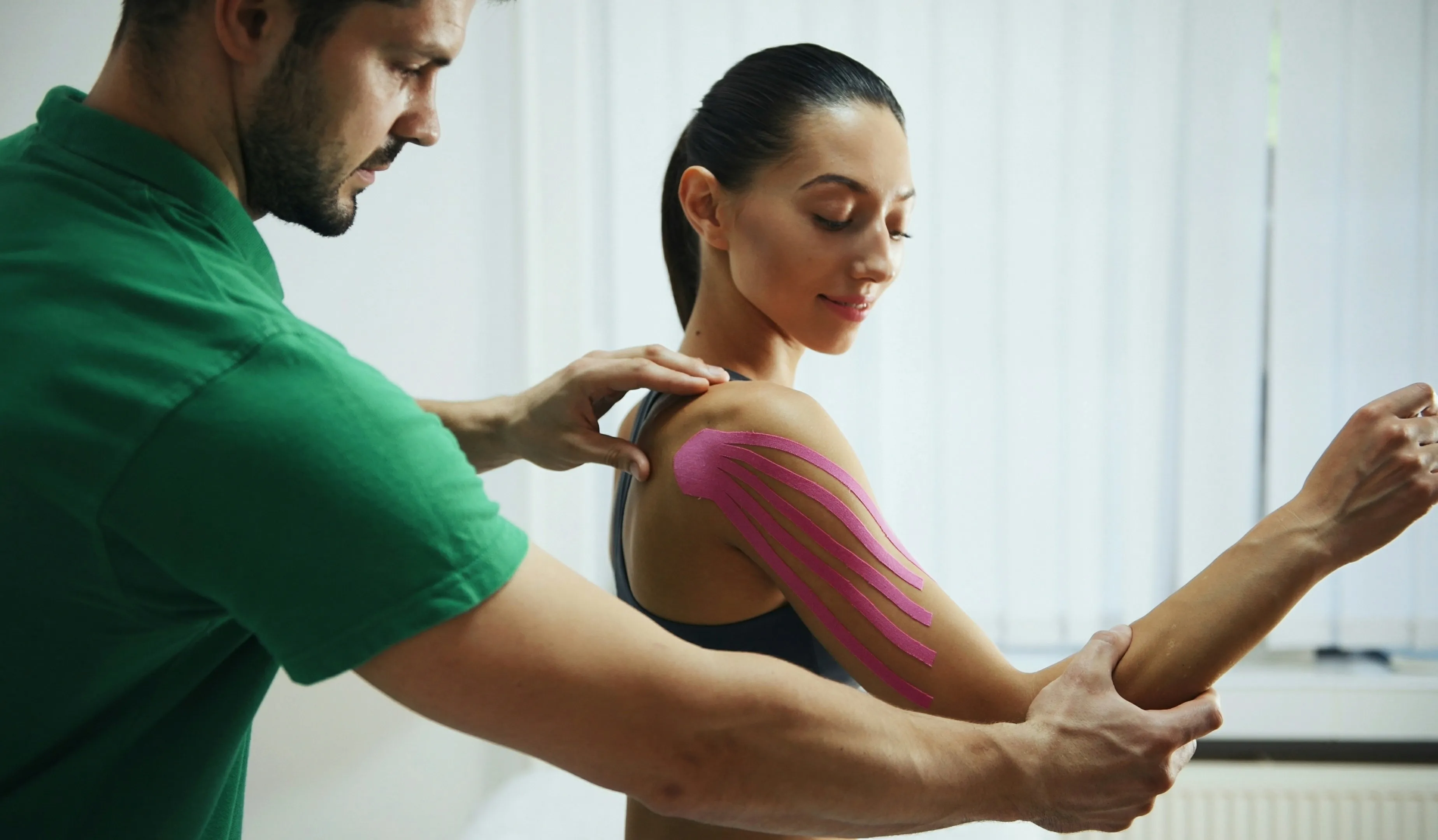 Fitness professional helping a client with a supported arm stretch