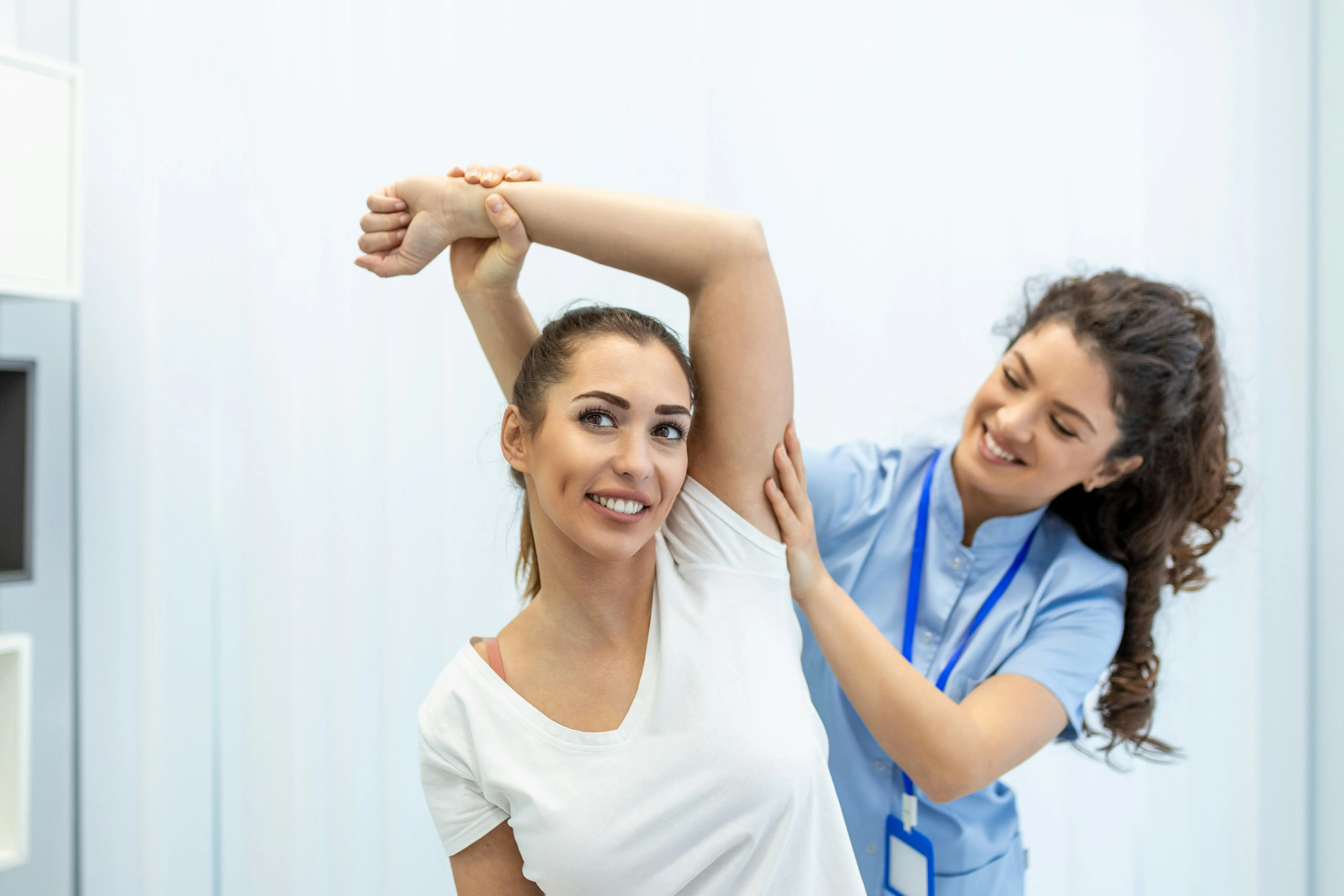 Kinesiologist guiding an upper-body mobility assessment during active rehabilitation